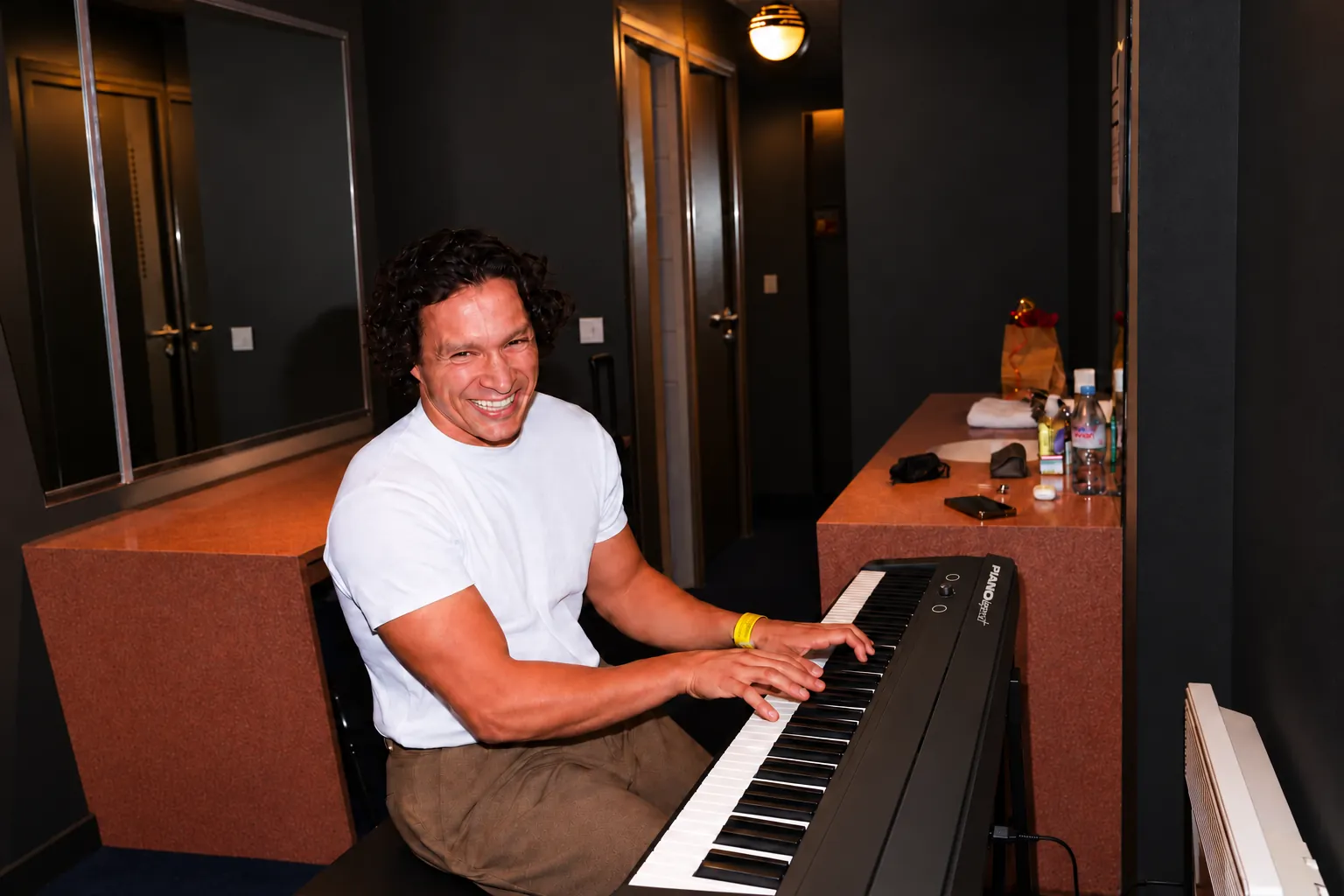 Adam Pamart, fondateur de Piano Legend, souriant, joue sur un Piano Legend.